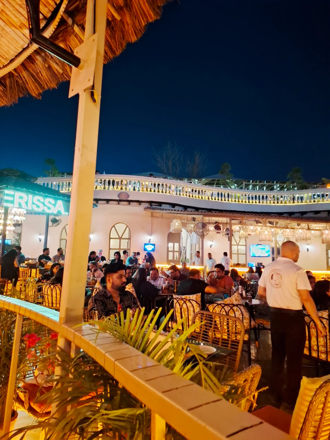 Guests seated at the rooftop lounge in the evening